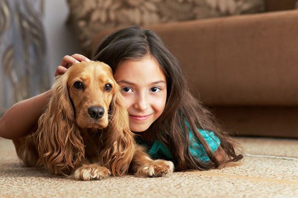Girl and her dog relaxing on a clean carpet