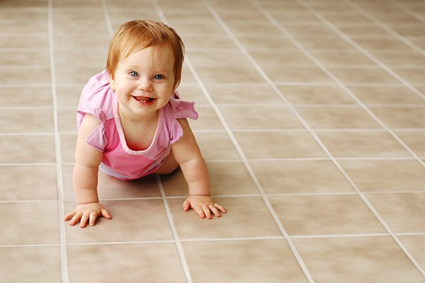 Baby crawling on a clean tile floor